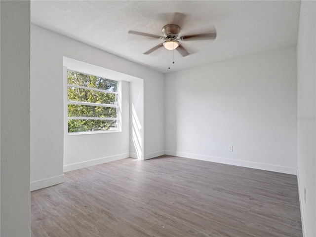 unfurnished room with hardwood / wood-style floors, ceiling fan, and a textured ceiling