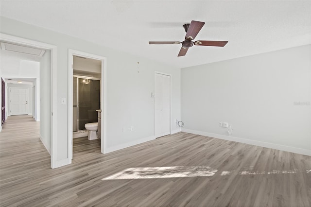 unfurnished bedroom with ensuite bathroom, a closet, light hardwood / wood-style floors, and ceiling fan