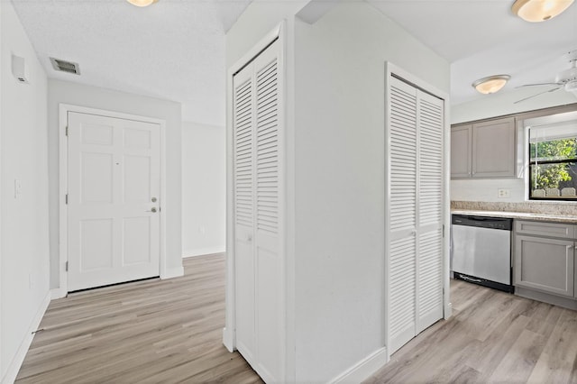 kitchen featuring light wood-type flooring, gray cabinets, stainless steel dishwasher, and ceiling fan