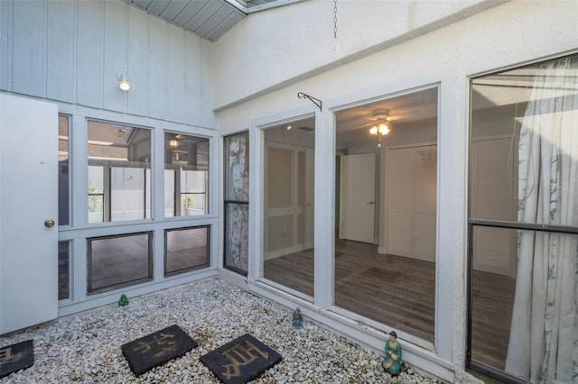 unfurnished sunroom with ceiling fan