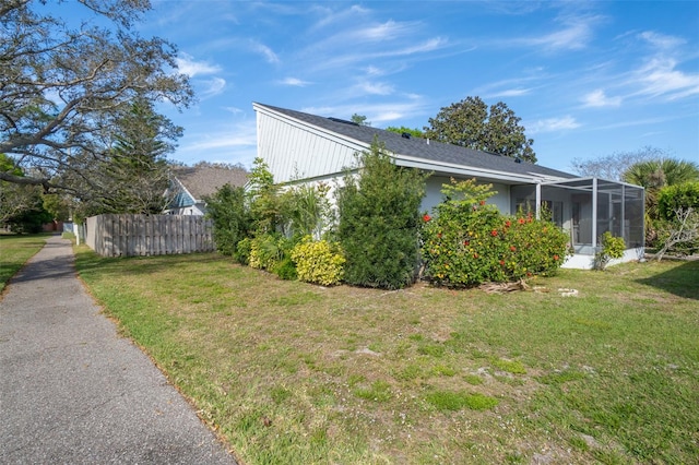 view of side of property with a lanai and a yard