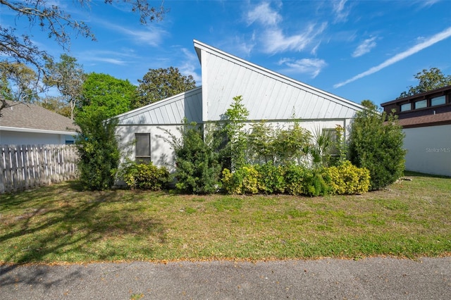 view of side of home with a yard