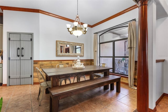 dining area with ornamental molding, decorative columns, and an inviting chandelier