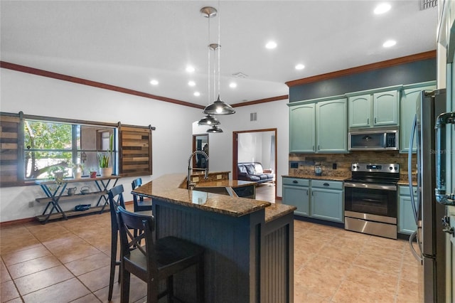 kitchen featuring stainless steel appliances, decorative backsplash, a barn door, crown molding, and decorative light fixtures