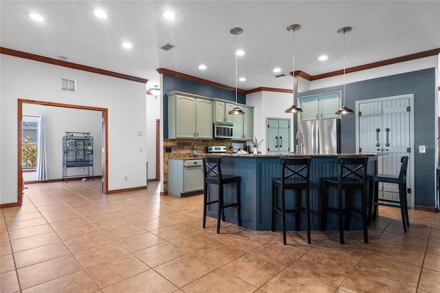 kitchen with ornamental molding, backsplash, appliances with stainless steel finishes, a kitchen bar, and hanging light fixtures