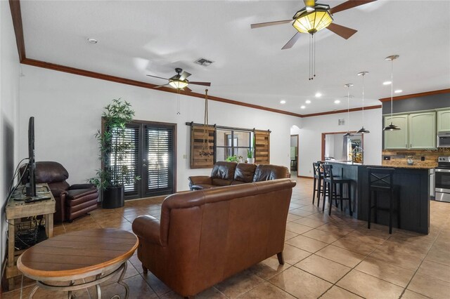 tiled living room with ceiling fan and crown molding