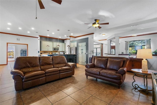 living room with ornamental molding, tile patterned flooring, and ceiling fan