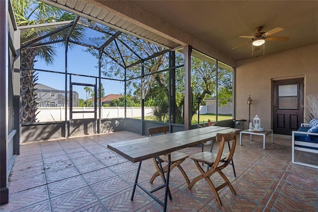 unfurnished sunroom featuring ceiling fan