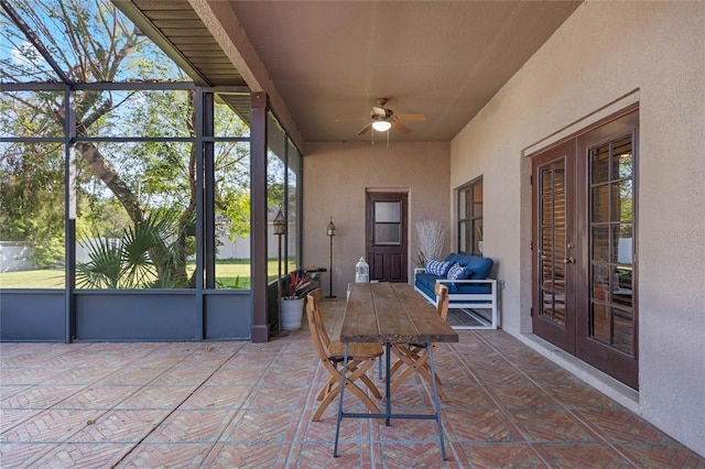 sunroom / solarium with french doors, a wealth of natural light, and ceiling fan