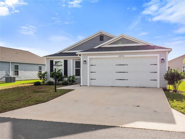 single story home with cooling unit, a garage, and a front lawn