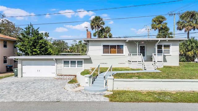 view of front of home with a garage and a front lawn