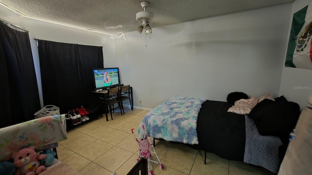 tiled bedroom featuring a textured ceiling and ceiling fan