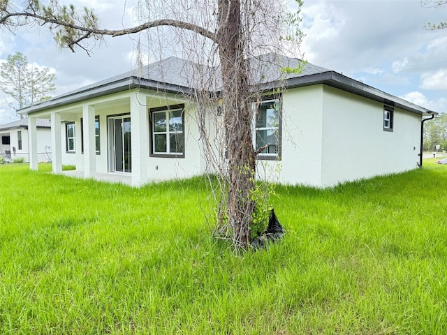 4683 Boston Ter, North Port, FL 34288 - view of property exterior with stucco siding and a lawn