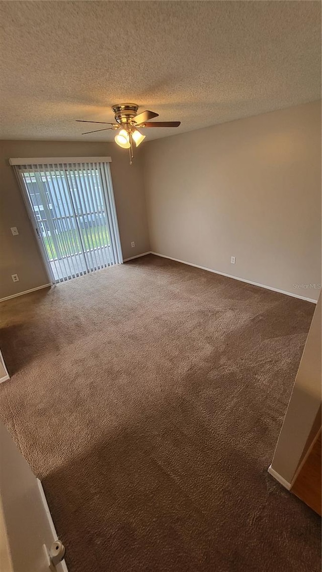 carpeted spare room featuring a textured ceiling and ceiling fan