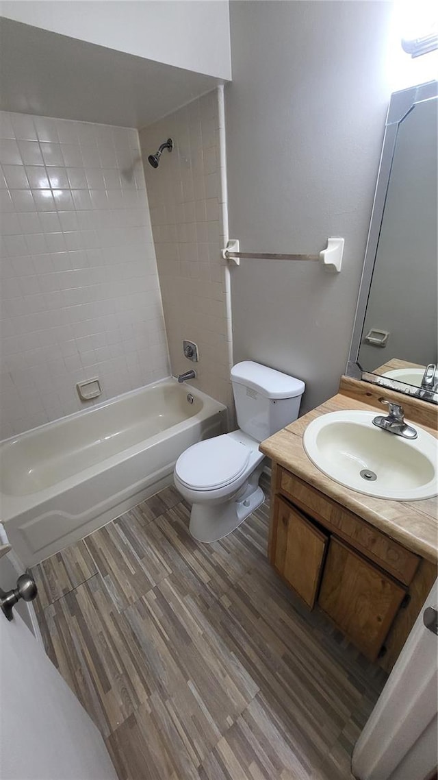 full bathroom with toilet, vanity, tiled shower / bath, and wood-type flooring