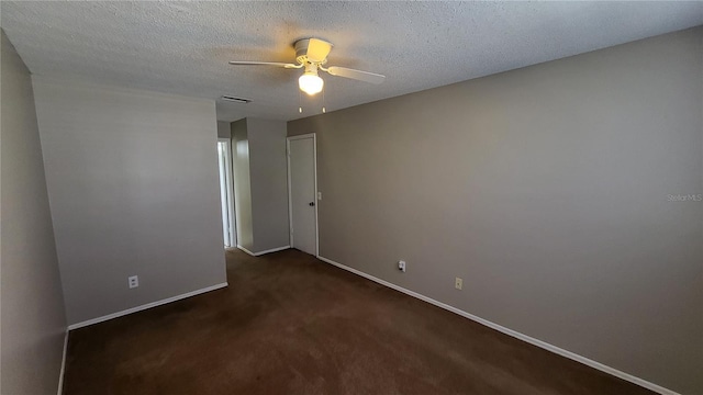 unfurnished room featuring a textured ceiling, dark colored carpet, and ceiling fan