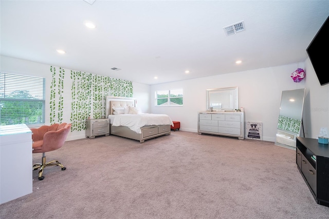 bedroom with multiple windows and light carpet