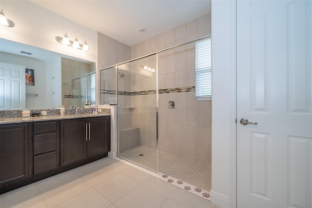 bathroom with tile patterned flooring, an enclosed shower, and vanity