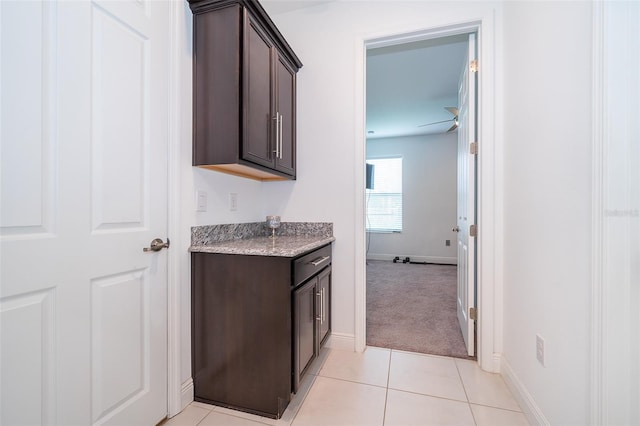 bathroom with ceiling fan and tile patterned flooring