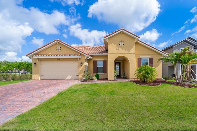 mediterranean / spanish-style house with a garage and a front lawn