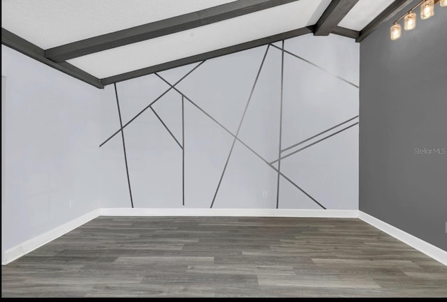 spare room featuring dark hardwood / wood-style flooring and lofted ceiling with beams