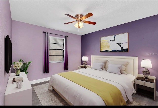 bedroom featuring wood-type flooring, a textured ceiling, and ceiling fan