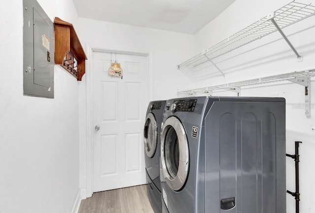 laundry area featuring washing machine and dryer, hardwood / wood-style floors, and electric panel