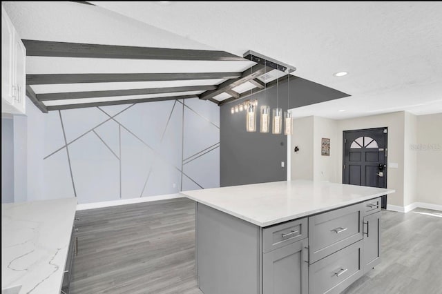 kitchen with gray cabinetry, dark wood-type flooring, a textured ceiling, decorative light fixtures, and a kitchen island