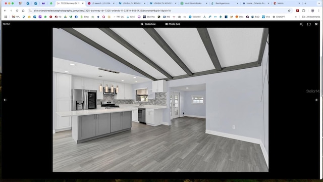 kitchen with white cabinetry, a center island, pendant lighting, and appliances with stainless steel finishes