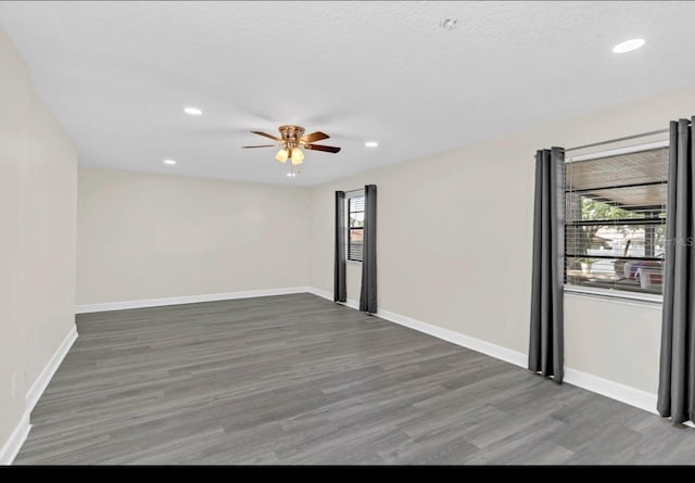 unfurnished room featuring dark hardwood / wood-style floors, ceiling fan, and a textured ceiling