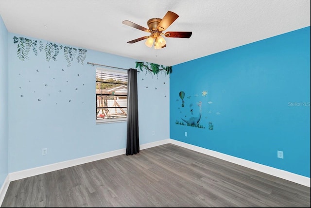 spare room with dark hardwood / wood-style floors, ceiling fan, and a textured ceiling