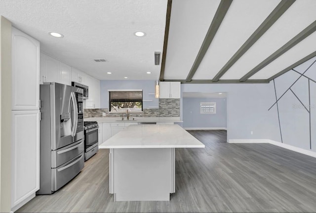 kitchen featuring appliances with stainless steel finishes, light wood-type flooring, and white cabinetry