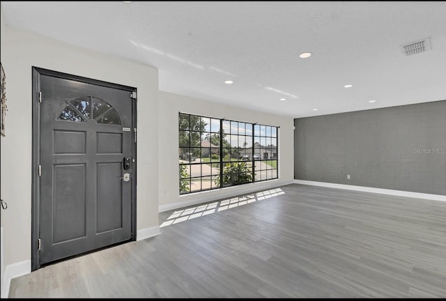 foyer entrance with wood-type flooring and a textured ceiling