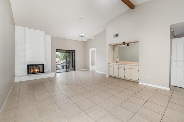 unfurnished living room featuring beamed ceiling, ceiling fan, light tile patterned floors, and a fireplace