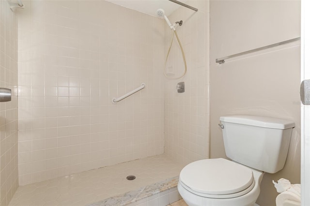 bathroom featuring tiled shower and toilet