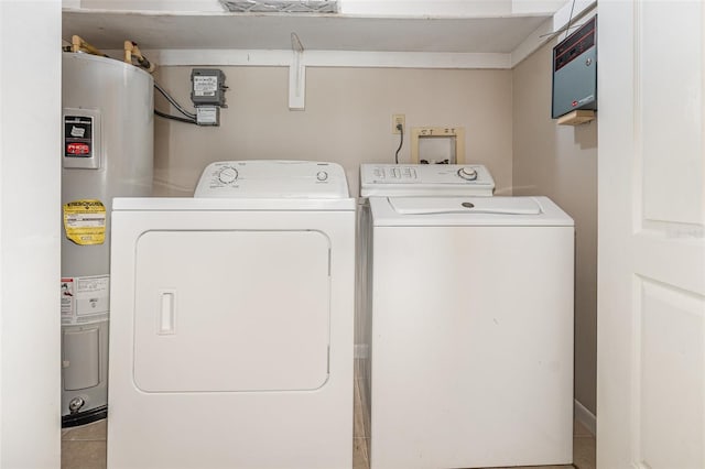 laundry room featuring electric water heater, separate washer and dryer, and light tile patterned floors