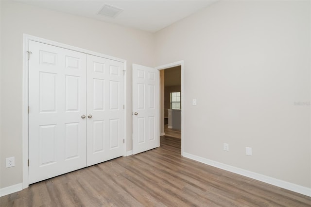 unfurnished bedroom with light hardwood / wood-style flooring and a closet