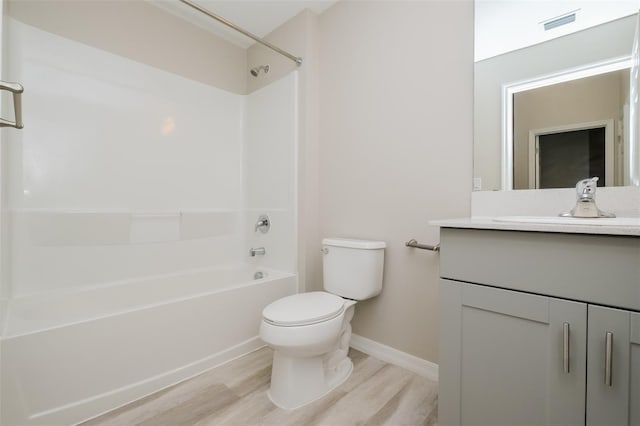 full bathroom featuring hardwood / wood-style floors, vanity, toilet, and  shower combination