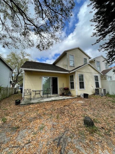 rear view of property featuring central AC, fence, and a patio