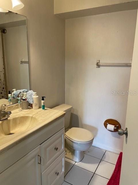 bathroom with tile patterned flooring, vanity, and toilet