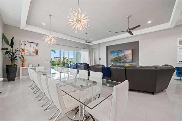 dining area featuring ceiling fan with notable chandelier, light tile patterned floors, and a tray ceiling