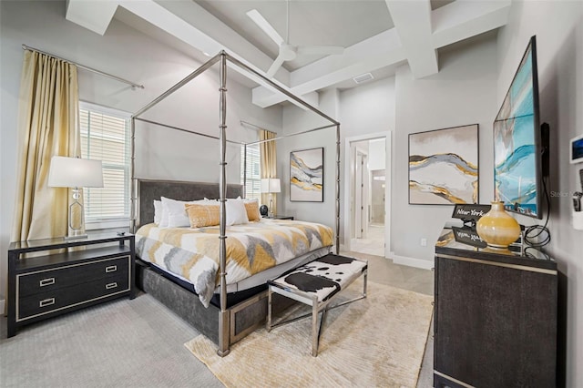 bedroom featuring coffered ceiling, ceiling fan, connected bathroom, and beam ceiling