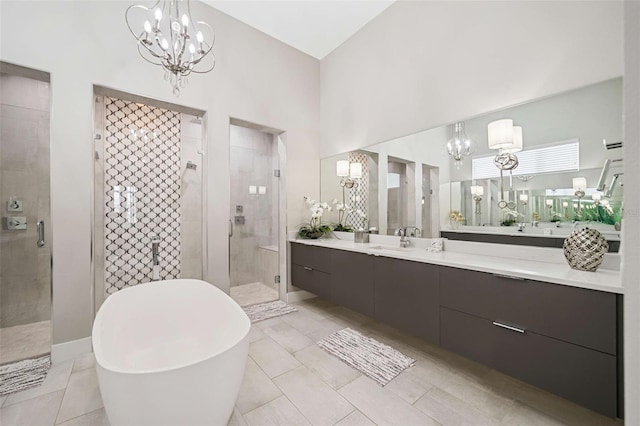 bathroom featuring a towering ceiling, shower with separate bathtub, tile patterned floors, and vanity