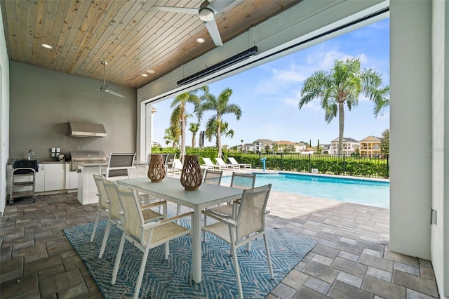 view of swimming pool featuring a patio, ceiling fan, area for grilling, and a grill