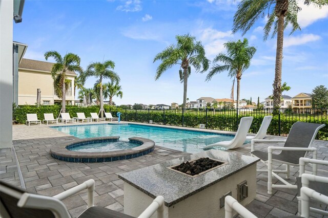 view of pool featuring an outdoor fire pit, an in ground hot tub, and a patio area