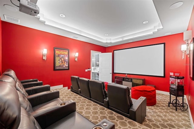 cinema with light carpet and a tray ceiling