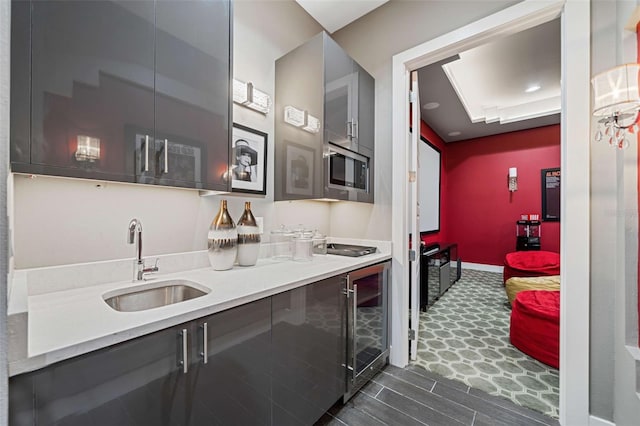 kitchen featuring stainless steel microwave, sink, and beverage cooler