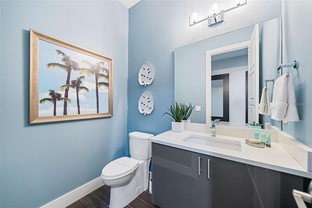 bathroom featuring toilet, vanity, and hardwood / wood-style floors