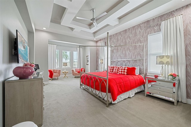 carpeted bedroom featuring ceiling fan and a raised ceiling