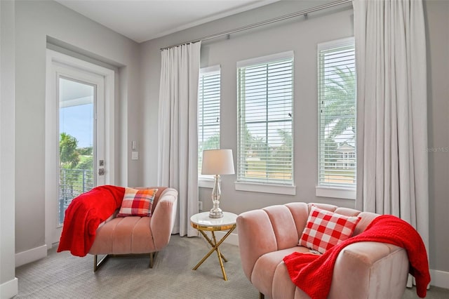 living area with plenty of natural light and light carpet